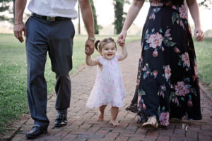 Image of baby walking holding mom and dad's hands. Image captured by Lexington, KY Photographer, Rhonda Cunningham Photography.