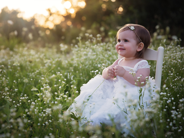 outdoor one year portrait session of baby girl in wildflowers by lexington ky newborn photographer rhonda cunningham photography