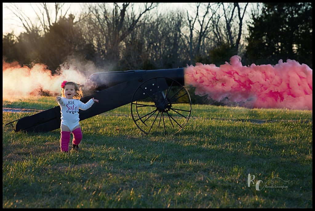 Gender reveal using a canon exploding with pink smoke by newborn photographer Rhonda Cunningham